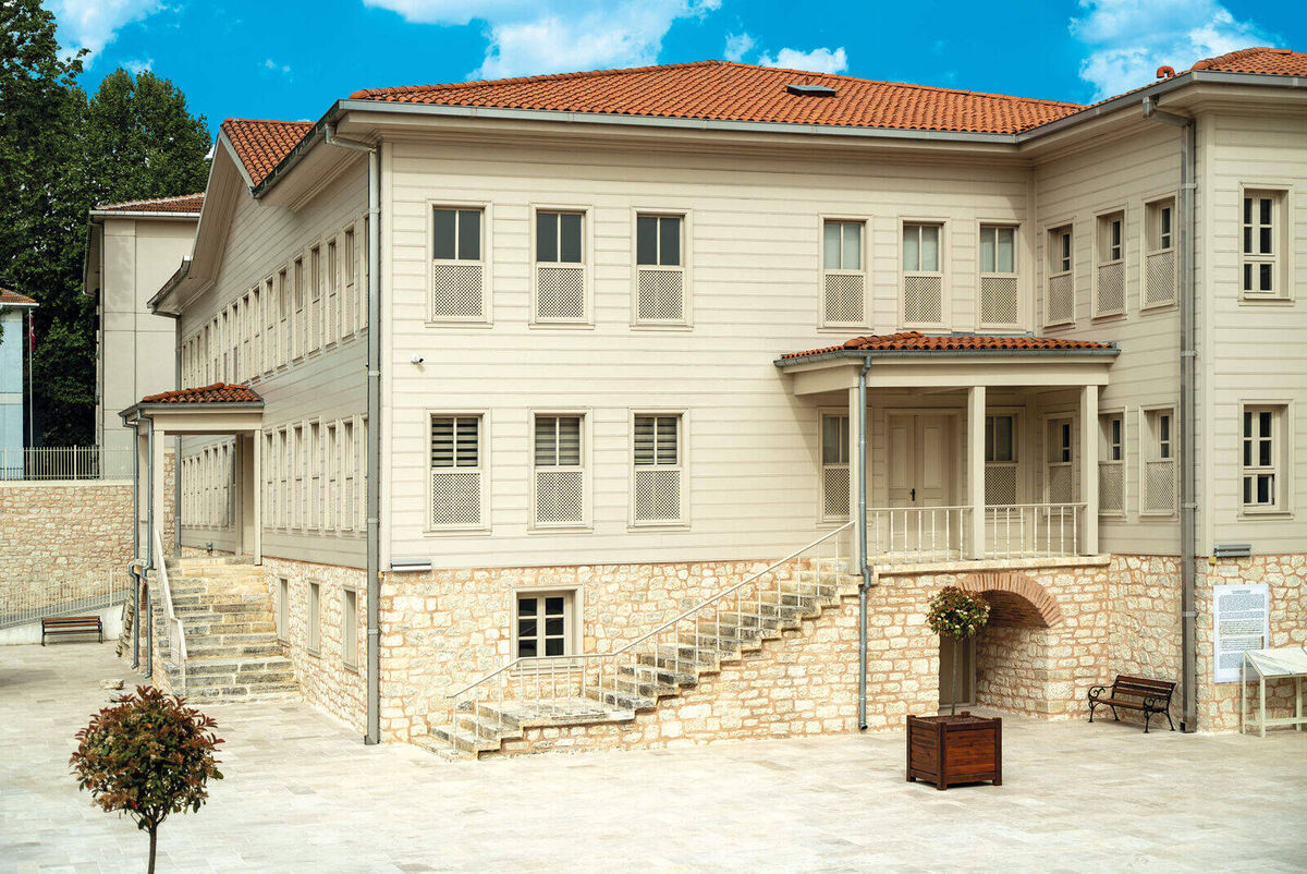 The rebuilt wooden-clad building of Kasımpaşa Mevlevihanesi with stone steps and its courtyard, Beyoğlu, Istanbul